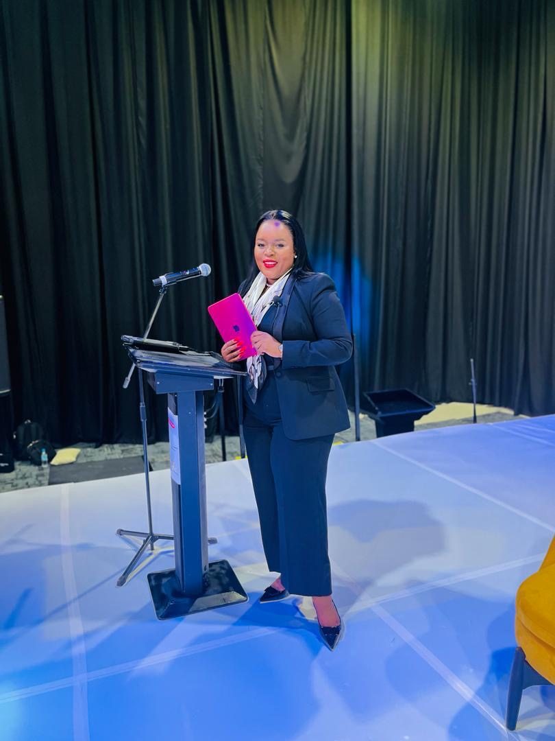 Segolame Thaga standing at a podium on a conference stage
